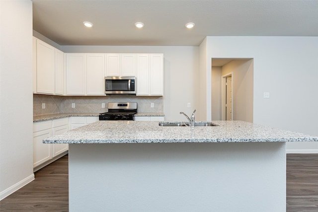 kitchen with a kitchen island with sink, white cabinetry, sink, and appliances with stainless steel finishes