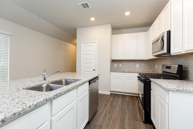 kitchen with decorative backsplash, appliances with stainless steel finishes, light stone countertops, sink, and white cabinets