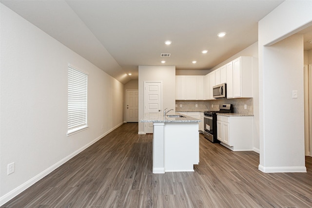 kitchen with appliances with stainless steel finishes, light stone counters, a kitchen island with sink, sink, and white cabinets