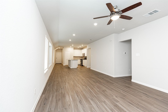 unfurnished living room featuring ceiling fan and light wood-type flooring