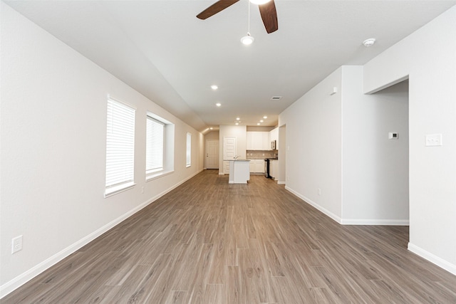 unfurnished living room with wood-type flooring and ceiling fan