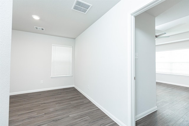 unfurnished room featuring ceiling fan and dark wood-type flooring