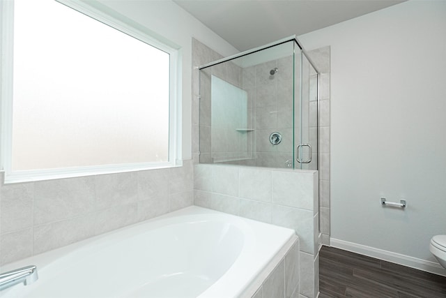 bathroom featuring shower with separate bathtub, hardwood / wood-style flooring, and toilet