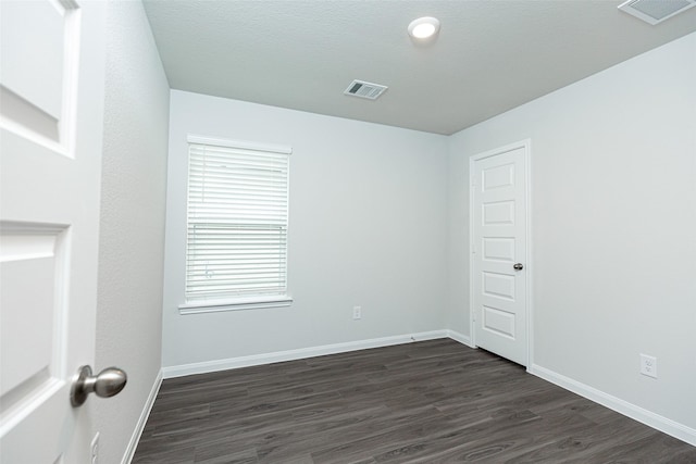 empty room featuring dark wood-type flooring