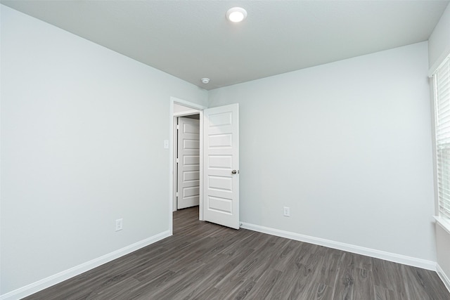 unfurnished bedroom with dark wood-type flooring