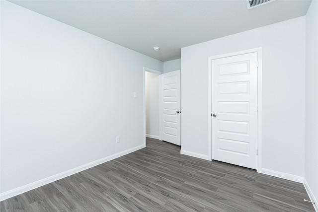 unfurnished bedroom with dark hardwood / wood-style floors and a closet