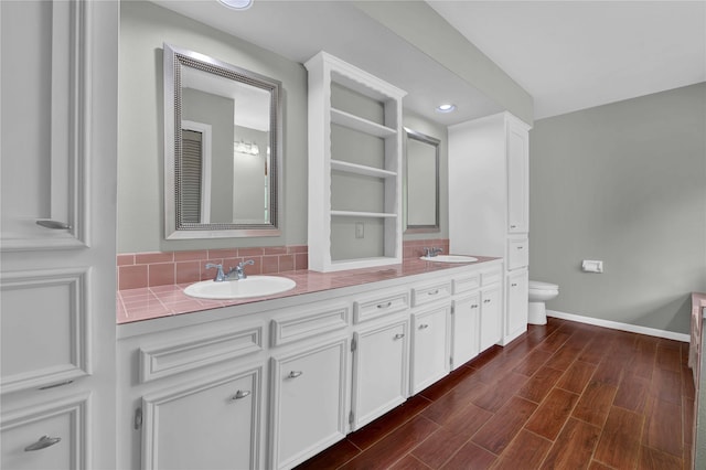 bathroom with hardwood / wood-style flooring, vanity, and toilet