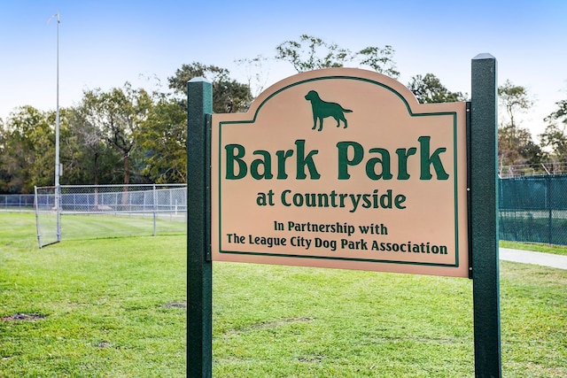 community / neighborhood sign featuring a yard