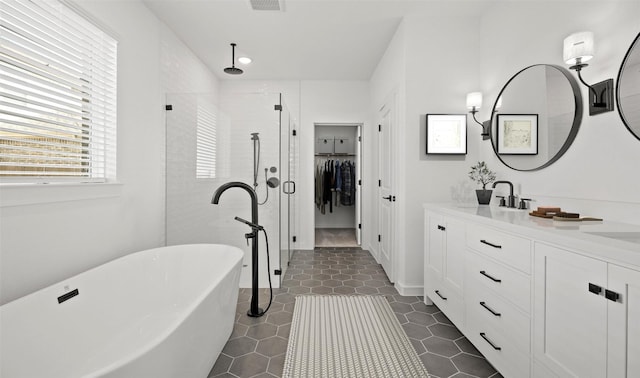 bathroom with tile patterned floors, separate shower and tub, and vanity