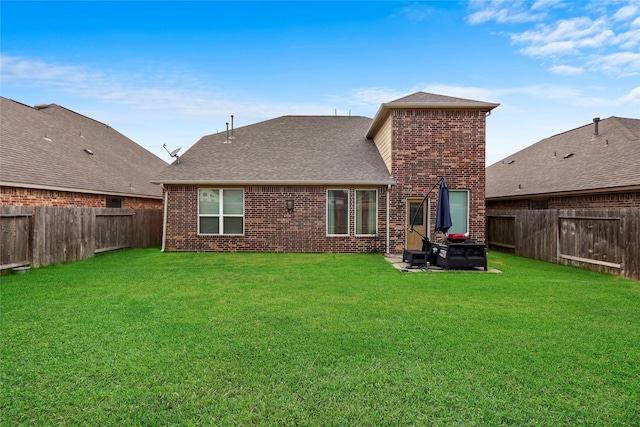 rear view of property featuring a lawn