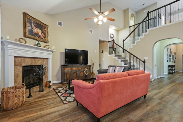 living room with a fireplace, dark hardwood / wood-style floors, ceiling fan, and high vaulted ceiling