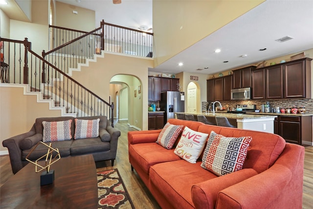 13423 Astley Acres Ln, Cypress, TX 77429 - living area with visible vents, wood finished floors, arched walkways, and stairs