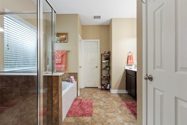 bathroom featuring independent shower and bath, vanity, and plenty of natural light