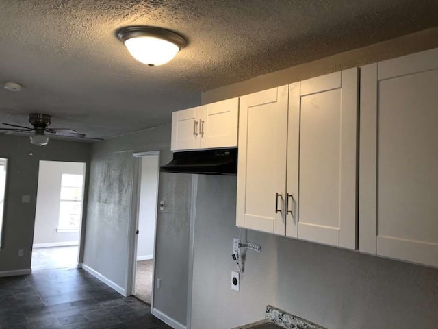 kitchen with ceiling fan, white cabinetry, and a textured ceiling