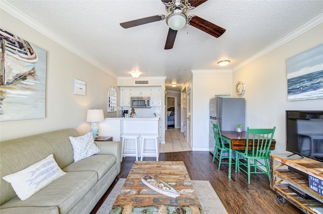 living room with ceiling fan, dark hardwood / wood-style flooring, crown molding, and a textured ceiling