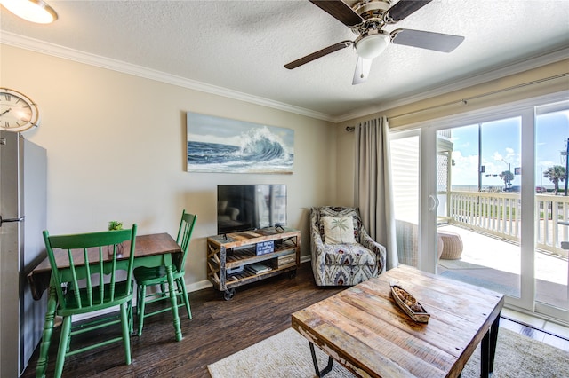 living room with ceiling fan, ornamental molding, dark hardwood / wood-style flooring, and a textured ceiling