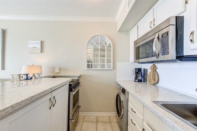 kitchen with light stone counters, white cabinetry, sink, washer / dryer, and a textured ceiling