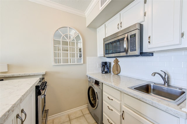 kitchen featuring washer / dryer, appliances with stainless steel finishes, sink, and decorative backsplash