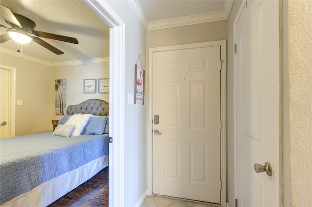 bedroom with crown molding, wood-type flooring, and ceiling fan