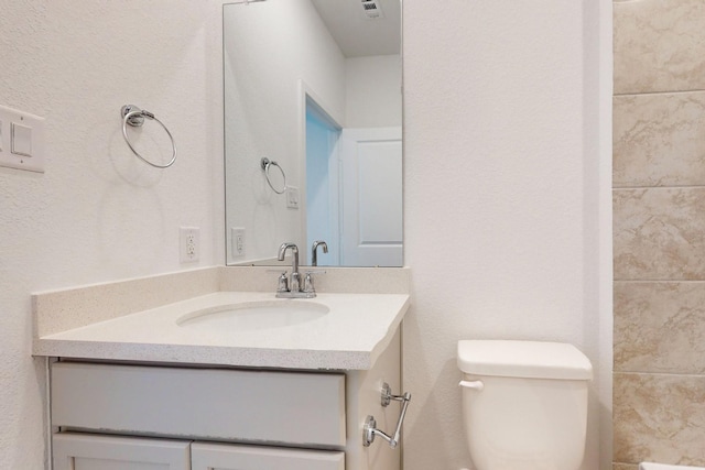 bathroom featuring toilet and vanity