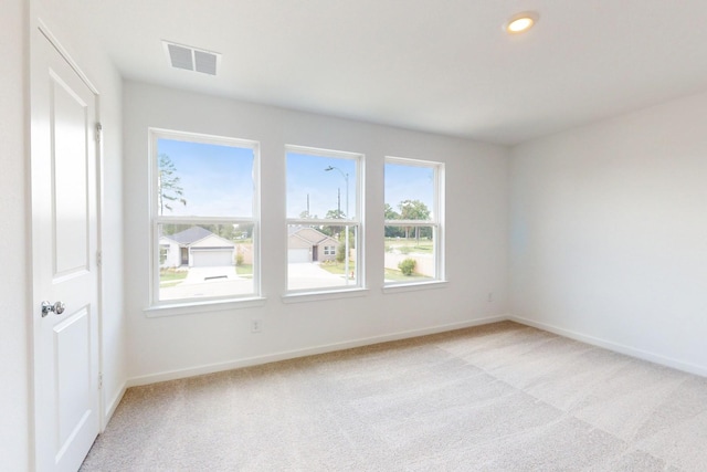 spare room with recessed lighting, visible vents, light carpet, and baseboards