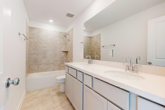 bathroom featuring toilet, double vanity, a sink, and visible vents