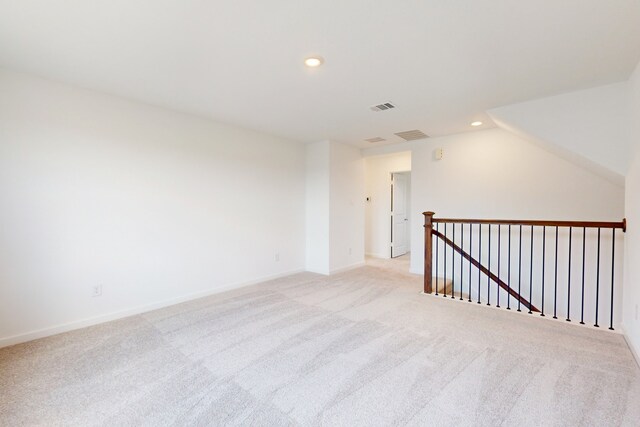 bonus room with light carpet and vaulted ceiling