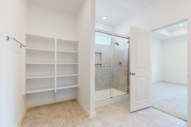 bathroom featuring walk in shower and tile patterned flooring