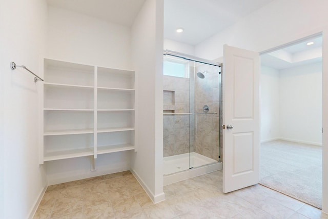 bathroom featuring recessed lighting, a shower stall, and baseboards