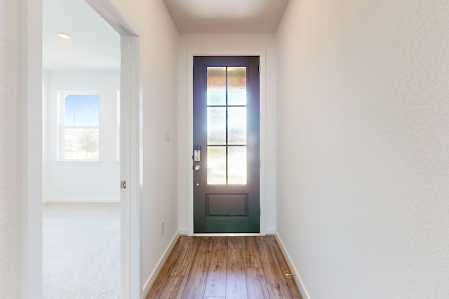 doorway featuring plenty of natural light and baseboards