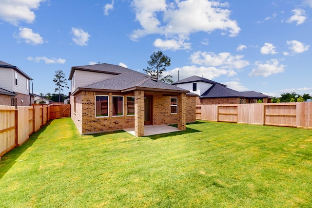 back of house with a fenced backyard, a lawn, a patio, and brick siding