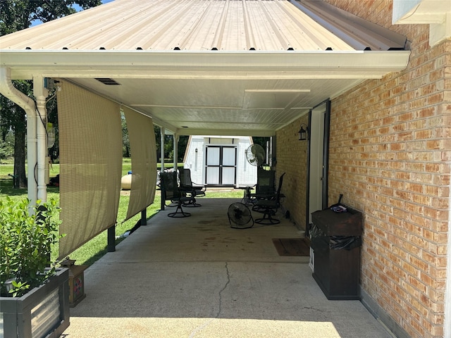 view of patio / terrace with a carport and a storage unit