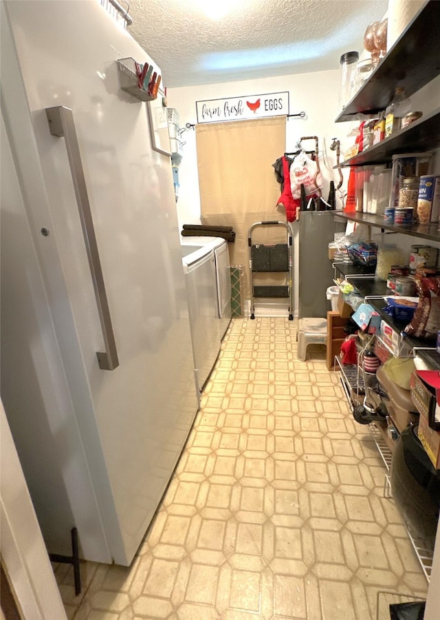 washroom with a textured ceiling and washing machine and clothes dryer