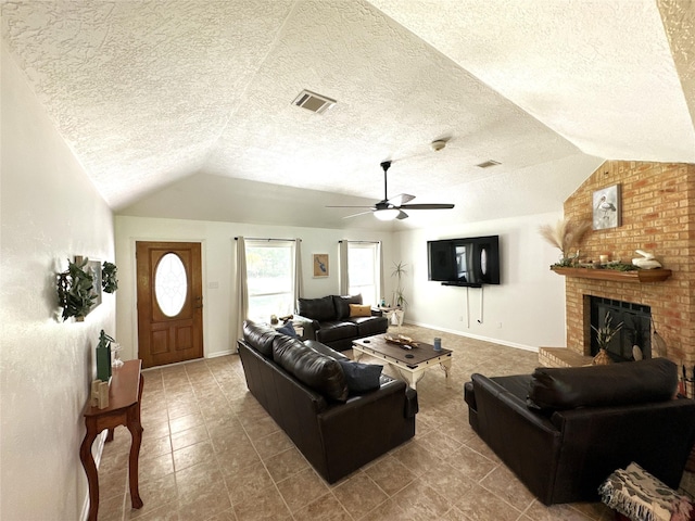 living room featuring a brick fireplace, a textured ceiling, vaulted ceiling, and ceiling fan