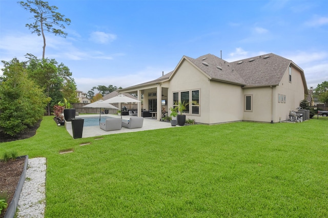 rear view of house featuring an outdoor living space, a yard, and a patio