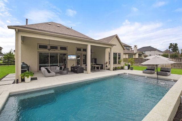 back of property with an outdoor hangout area, a fenced in pool, and a patio area