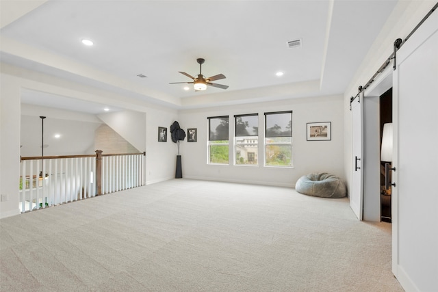 interior space with ceiling fan and a tray ceiling