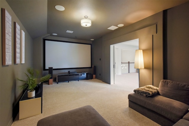 carpeted cinema room featuring vaulted ceiling