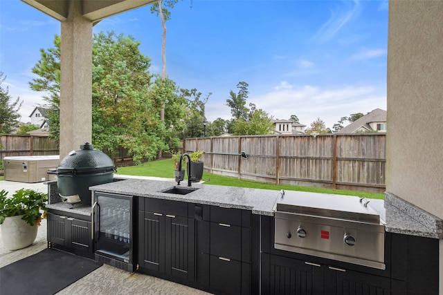 view of patio / terrace featuring grilling area, sink, exterior kitchen, and beverage cooler