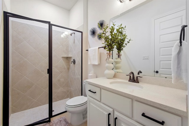 bathroom featuring vanity, toilet, and a shower with door