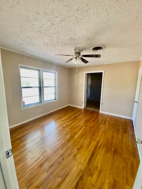 unfurnished room featuring hardwood / wood-style floors, a textured ceiling, and ceiling fan