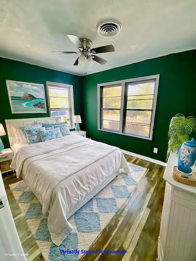 bedroom with dark hardwood / wood-style flooring, multiple windows, and ceiling fan