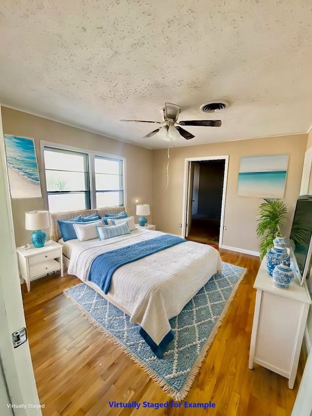 bedroom featuring a textured ceiling, hardwood / wood-style flooring, and ceiling fan