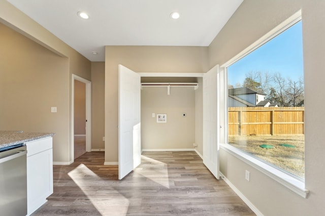 interior space with plenty of natural light, hookup for an electric dryer, and light wood-type flooring