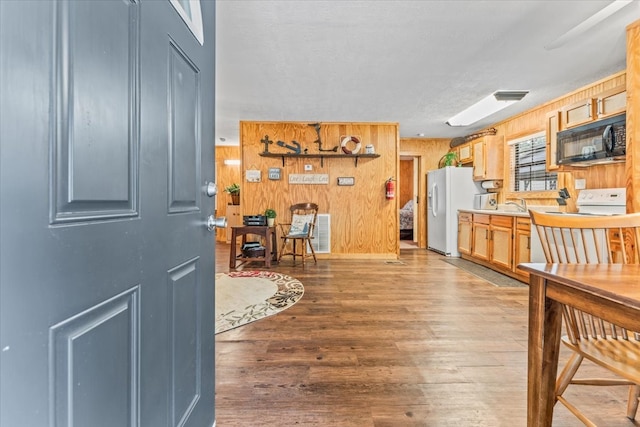 foyer with wooden walls, a textured ceiling, hardwood / wood-style floors, and sink