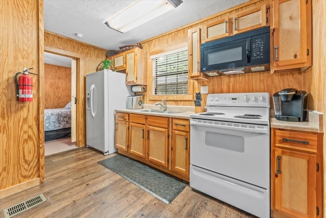 kitchen with a textured ceiling, light hardwood / wood-style flooring, sink, and white appliances