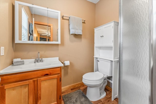 bathroom with wood-type flooring, vanity, and toilet