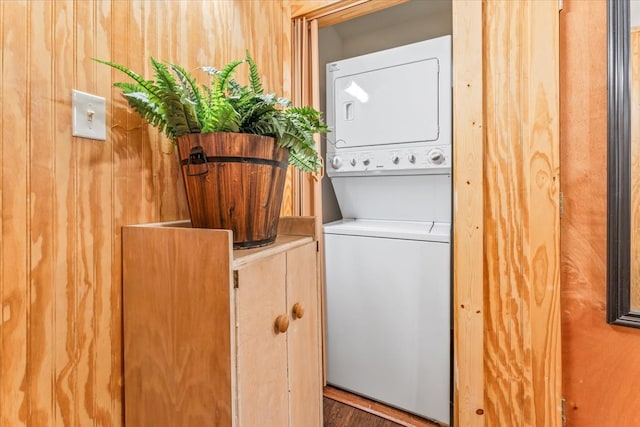 laundry room featuring dark wood-type flooring and stacked washer and clothes dryer