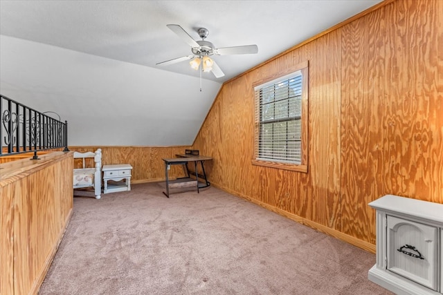 bonus room with ceiling fan, light colored carpet, lofted ceiling, and wood walls