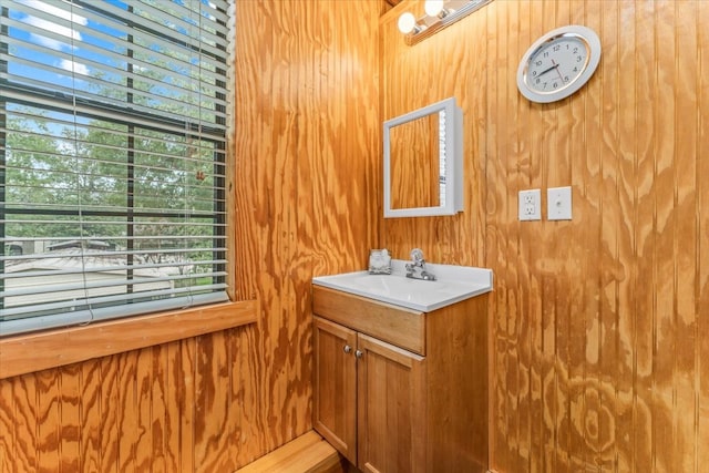 bathroom featuring a wealth of natural light, vanity, and wooden walls